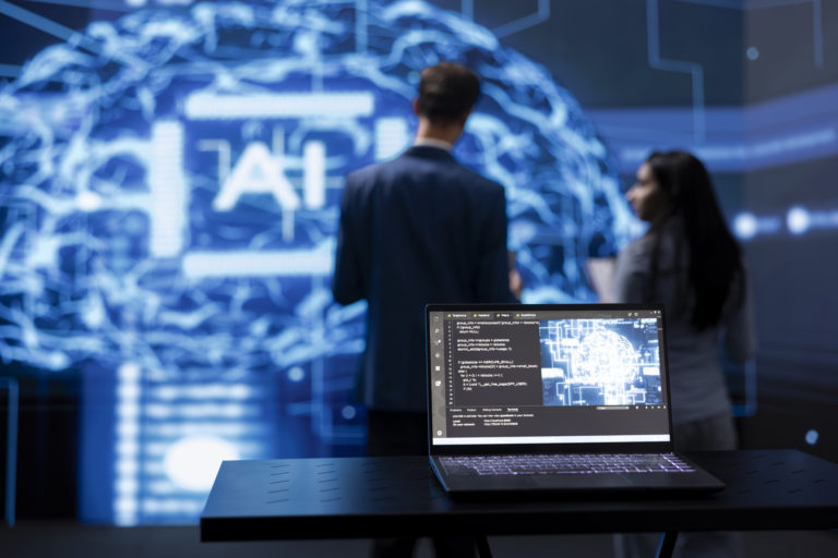 People reviewing an AI interface with a laptop in the foreground